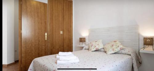 Apartamento Machado Vejer في فيجير دي لا فرونتيرا: غرفة نوم بسرير وخزانة خشبية