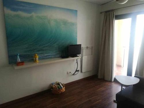 uma sala de estar com uma pintura do oceano na parede em Apartamento Moderno with AirCo em Oliva