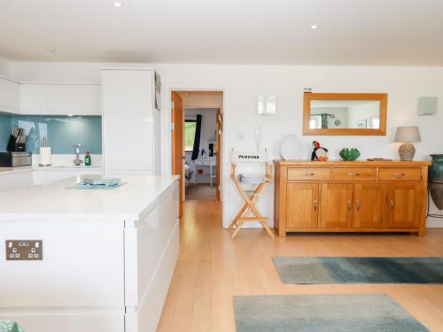 a kitchen with white counters and a wooden cabinet at 4 Burgh Island Causeway in Kingsbridge