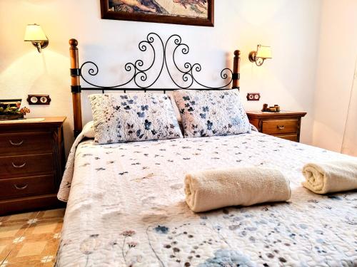 a bedroom with a large bed with a metal headboard at Alojamiento La Nave de Zuheros in Zuheros