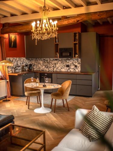 une cuisine et un salon avec une table et des chaises dans l'établissement Les Arts - Cocon romantique en Baie de Somme, à Boismont