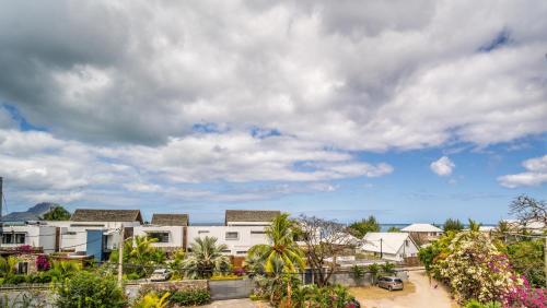 a view of a city with buildings and palm trees at Charming Condo in Rivière Noire