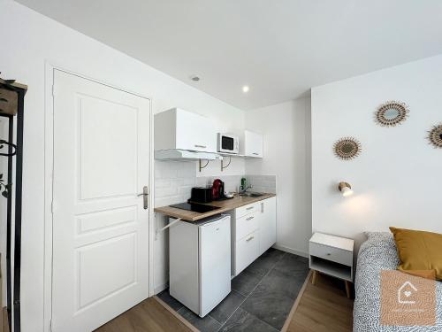 a small kitchen with a white door and a room at Les studios d'Elina - Entrée autonome in Châtellerault