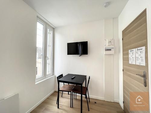 a room with a table and a chair and a door at Les studios d'Elina - Entrée autonome in Châtellerault