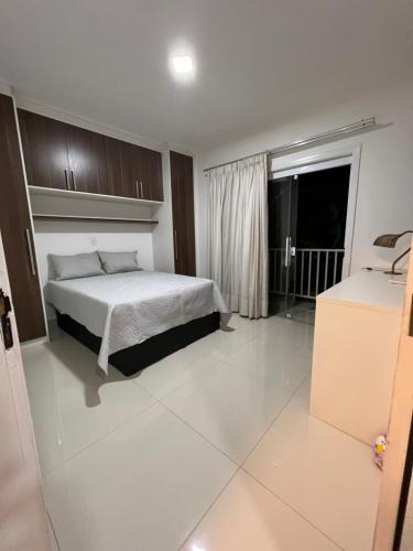 a bedroom with a white bed and a window at CasaparkIndaiatuba in Indaiatuba
