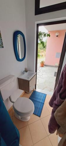 een badkamer met een toilet, een wastafel en een spiegel bij La Civetta - Relax tra verde e mare a 10 minuti da Sestri Levante in Casarza Ligure