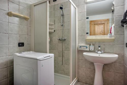 ein Bad mit einem Waschbecken, einem WC und einer Dusche in der Unterkunft Giongo Residence Aparthotel 101 in Lavarone