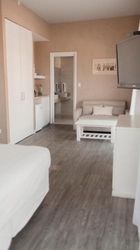 a white living room with a couch and a tv at Atlántico Boutique Hotel in Punta del Este