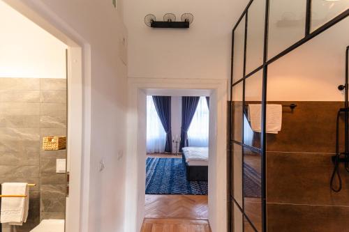 a bathroom with a walk in shower next to a bedroom at Schiller Rooms in Sibiu