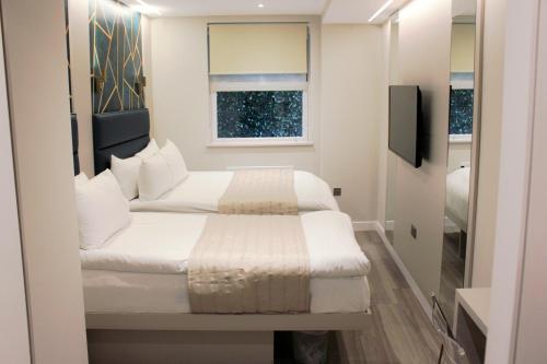 niewielka sypialnia z 2 łóżkami i oknem w obiekcie NOX Richmond w mieście Richmond
