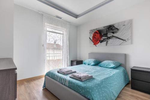 Schlafzimmer mit einem Bett mit blauer Bettwäsche und einem Fenster in der Unterkunft Maison duplex 3 chambres à 6km de Bordeaux centre in Floirac