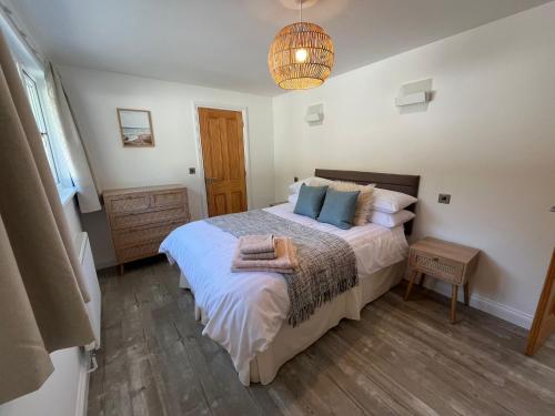 a bedroom with a large bed with blue pillows at Berllan Deg in Cardigan