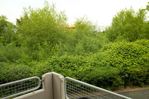 a bridge over a road with bushes and trees at Hotel Senator in Bielefeld