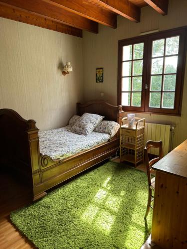 Maison de campagne cosy dans la verdure في Champniers: غرفة نوم بسرير وسجادة خضراء