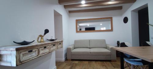 sala de estar con sofá y espejo en La Bombonera del Berguedà, en Sant Jordi de Cercs