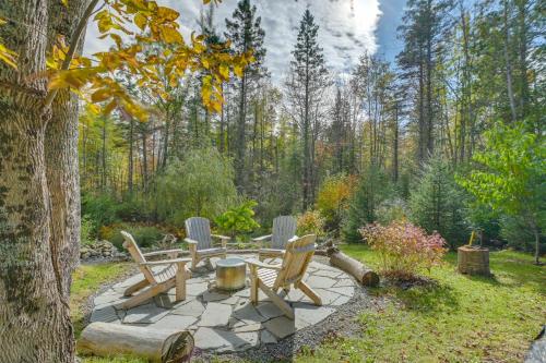 a patio with chairs and a table in the woods at Ellsworth Home about 18 Mi to Acadia Natl Park! in Ellsworth