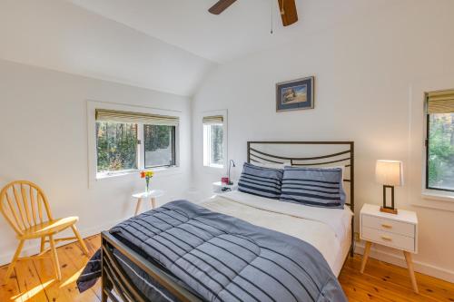 a bedroom with a bed and a chair and windows at Ellsworth Home about 18 Mi to Acadia Natl Park! in Ellsworth