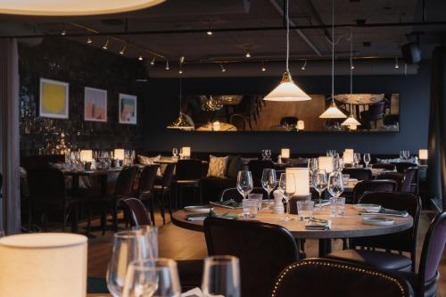 una sala da pranzo con tavoli, sedie e luci di Clarion Hotel Stockholm a Stoccolma
