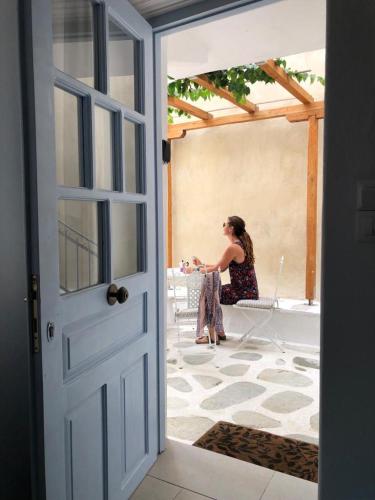 a woman sitting at a table on a patio at The Guest House in Skiathos