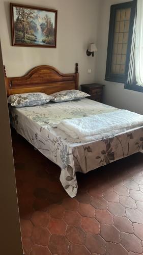 1 dormitorio con 1 cama grande con marco de madera en Hostal Sabor Fusion, en La Pradera de Navalhorno