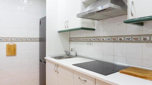 cocina blanca con fregadero y fogones en Apartment Alhamar Beach Mijas, en Mijas