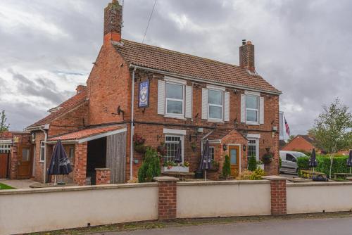 a brick house with an umbrella in front of it at Eyre arms 