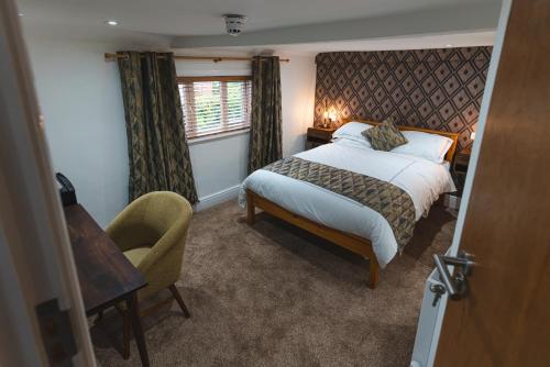 a bedroom with a bed and a chair and a window at Eyre arms 