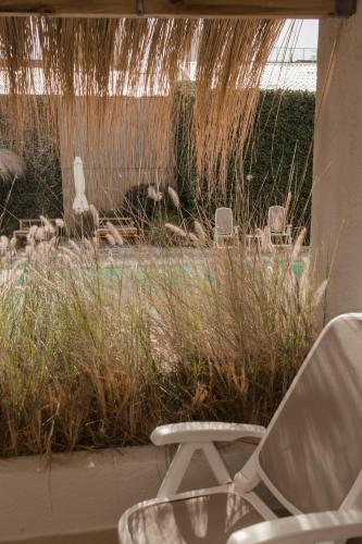 a white chair sitting in front of a yard at Atlántico Boutique Hotel in Punta del Este