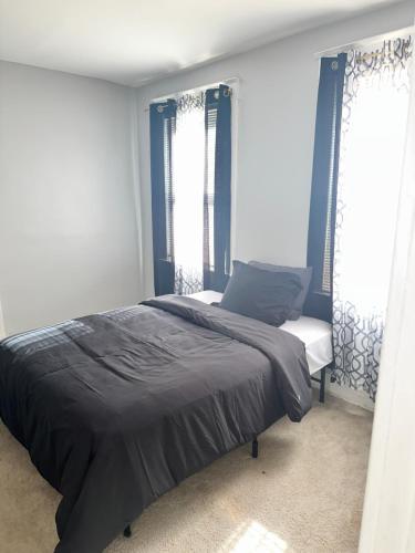 1 dormitorio con 1 cama y 2 ventanas en Experience Charm City in this Stunning Gem! en Baltimore