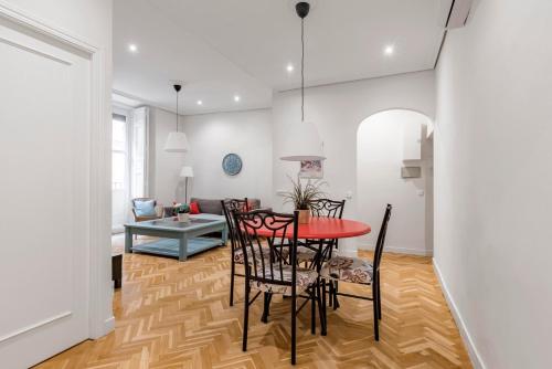 comedor y sala de estar con mesa roja y sillas en GuestReady - Trendy residence near Plaza Mayor, en Madrid