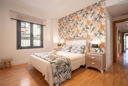 a bedroom with a bed and a wall with flowers at EnjoyGranada ARCOIRIS in Granada
