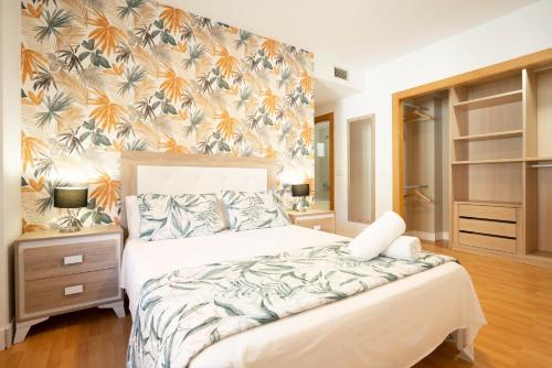 a bedroom with a bed with a tropical wallpaper at EnjoyGranada ARCOIRIS in Granada