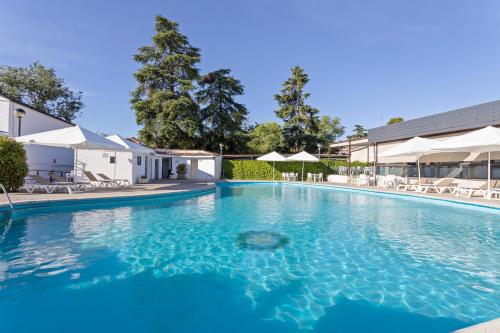 een groot zwembad met blauw water bij Hotel Best Osuna in Madrid