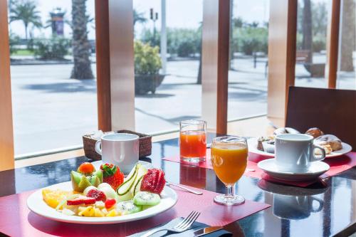 una mesa con un plato de fruta y zumo en Hotel Best Front Maritim, en Barcelona