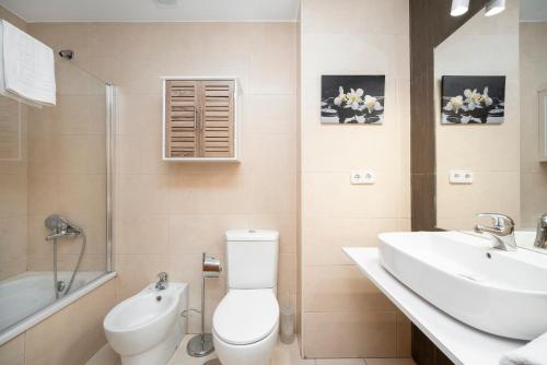a bathroom with a toilet and a sink and a tub at EnjoyGranada ARCOIRIS in Granada