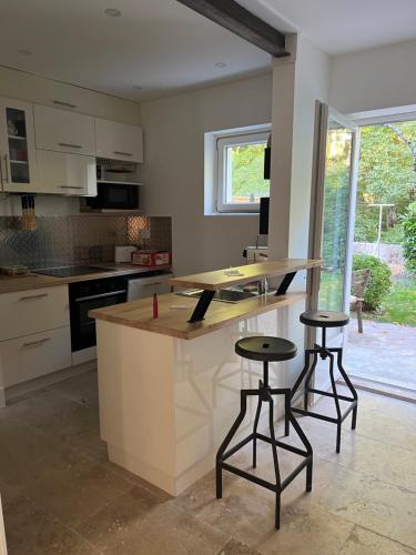 - une cuisine avec un comptoir et deux tabourets dans l'établissement Côté rivière, à Venarey-les-Laumes