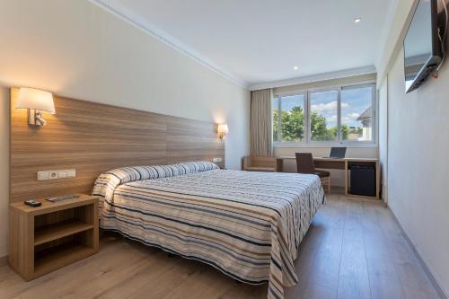Habitación de hotel con cama y escritorio en Hotel Best Osuna, en Madrid
