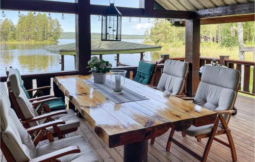 a wooden table and chairs on a deck with a view of the water at Awesome Home In Glava With Sauna in Glava