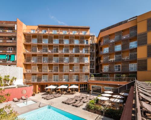 uma vista para um hotel com piscina, cadeiras e guarda-sóis em ALEGRIA Plaza Paris 4*Sup em Lloret de Mar