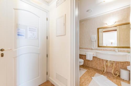 a bathroom with a tub and a toilet and a sink at Villa Fiorita in Monastier di Treviso