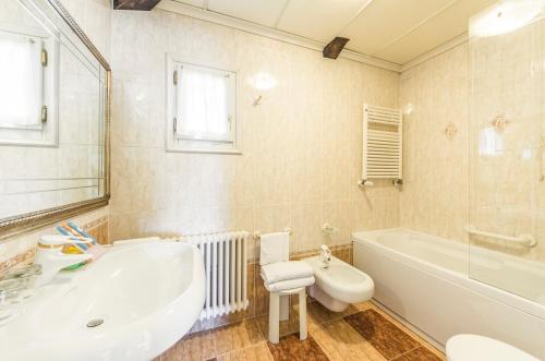 a bathroom with a tub and a toilet and a sink at Villa Fiorita in Monastier di Treviso