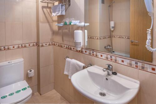 a bathroom with a sink and a toilet and a mirror at Hotel Moremar by ALEGRIA in Lloret de Mar