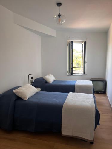 2 Betten in einem Zimmer mit Fenster in der Unterkunft Adelaide al Borgo. in Castelnuovo di Porto