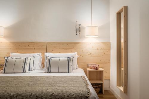 a bedroom with a bed with white sheets and pillows at ALEGRIA Mariner in Lloret de Mar