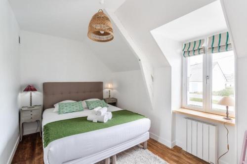 une chambre avec un lit avec un animal en peluche dessus dans l'établissement La maison d'Amélie Cancale, à Cancale