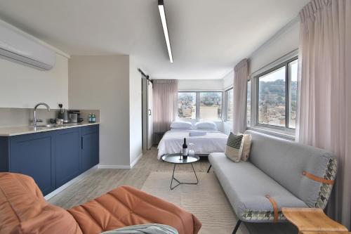 - un salon avec un canapé et un lit dans l'établissement ROOFTOP 42 - Studio, à Haïfa