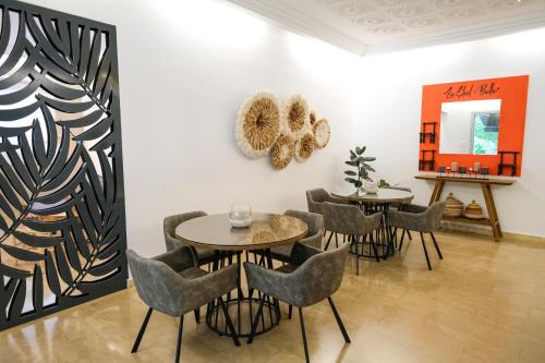 a dining room with two tables and chairs at Villa Ayaba in Abidjan