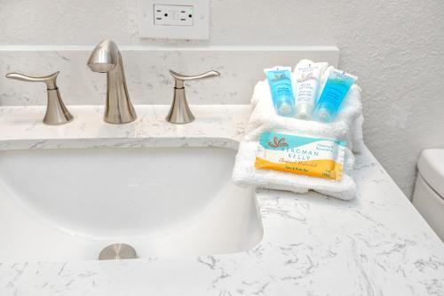a bathroom sink with toothbrushes and toothpaste at 7 People 4 Beds - 8 mins to beach by car - 2 mins to downtown - MODERN in Largo