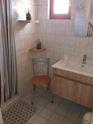 La salle de bains est pourvue d'une chaise et d'un lavabo. dans l'établissement Gite Entre Pierre et Come, à Chablis