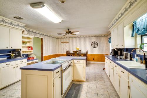 a large kitchen with white cabinets and blue counter tops at Charming Lake Charles Home with Patio and Grill in Lake Charles